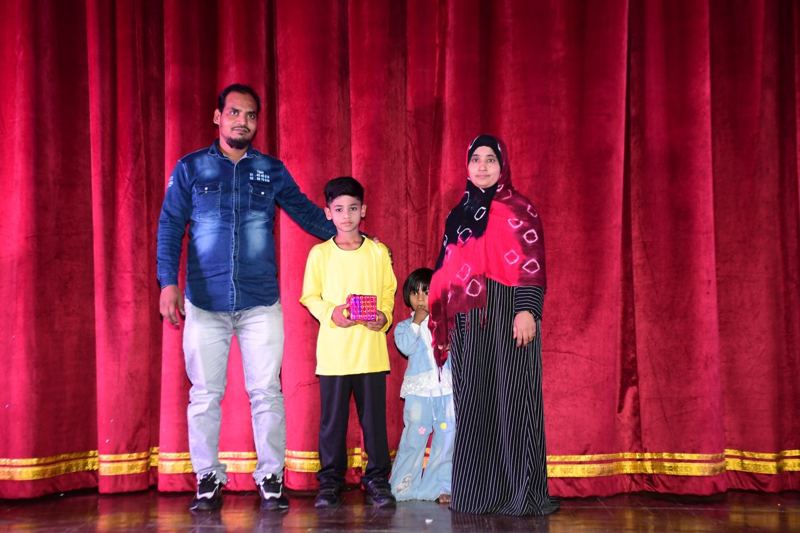 A student receiving a prize with his family