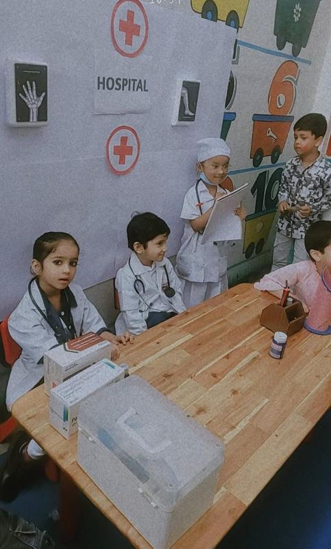 Nursery children playing doctor in a Montessori role-play corner
